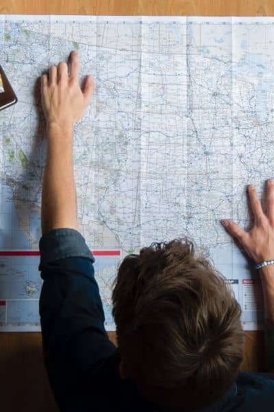 Person reviewing a detailed land map and boundary survey plans on a desk to ensure property accuracy