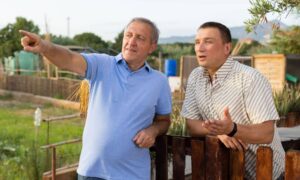 Neighbors discussing a property line issue near a fence before getting a house survey