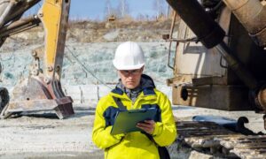 Engineer reviewing documents and maps on site before a property line survey