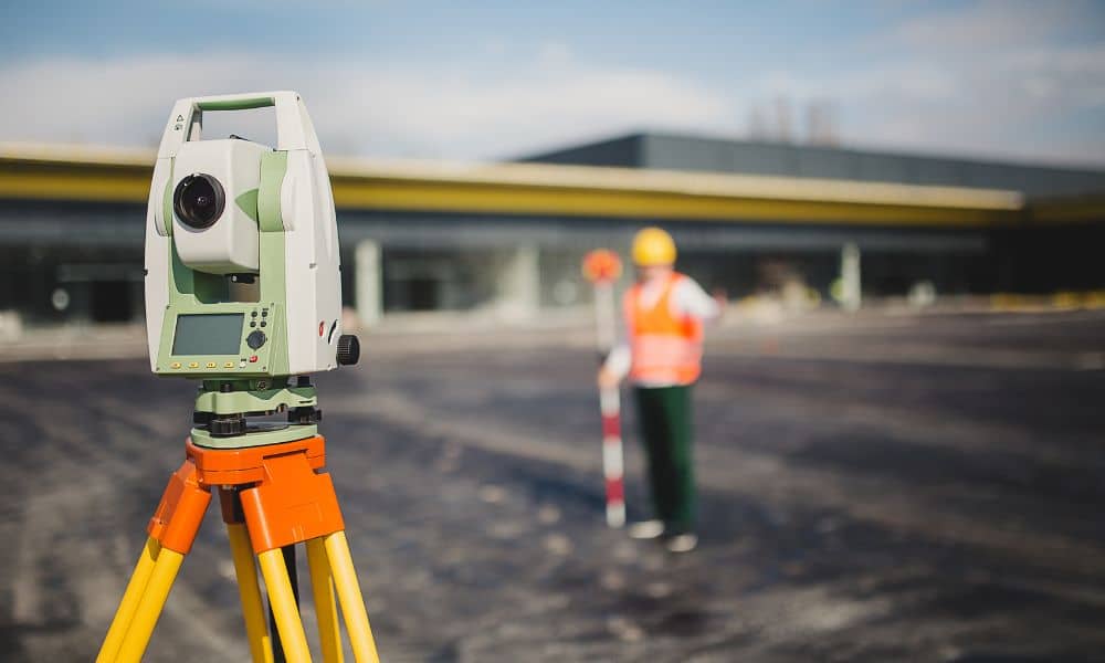 Commercial property survey with total station - ALTA SURVEY Minnesota Surveyor using a total station to map a commercial property during an alta title survey