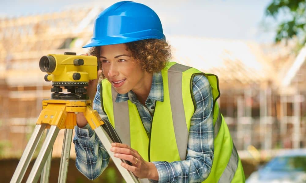 Commercial property surveyor conducting a site visit using professional surveying equipment in an urban construction area