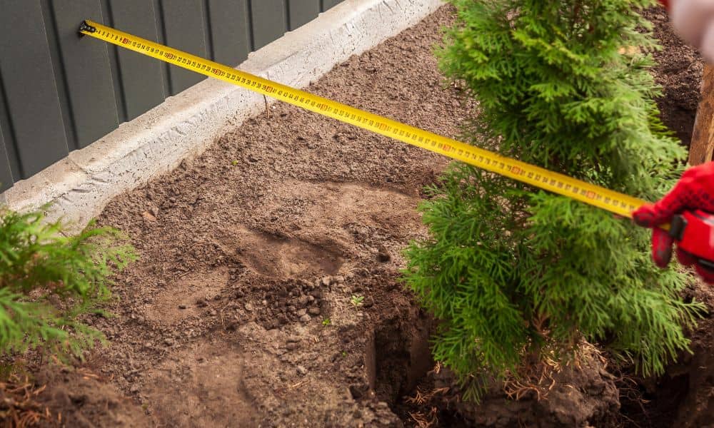 Measuring backyard yard - ALTA SURVEY Minnesota Homeowner measuring the property line in their backyard before building a fence