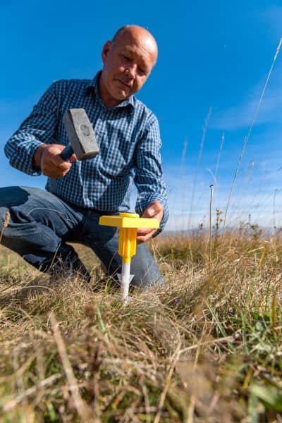 Property boundary marker installation - ALTA SURVEY Minnesota Surveyor installing a boundary marker during a house survey to confirm property lines