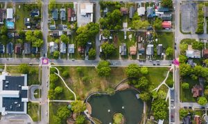 Survey mapping stormwater runoff planning - ALTA SURVEY Minnesota Aerial view of a neighborhood with roads, green spaces, and a pond used to illustrate survey mapping for stormwater planning